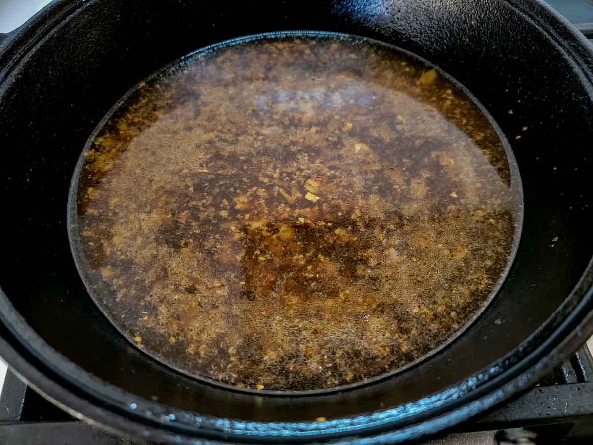 beef broth and sugar added to the bourbon sauce in the cast iron skillet.