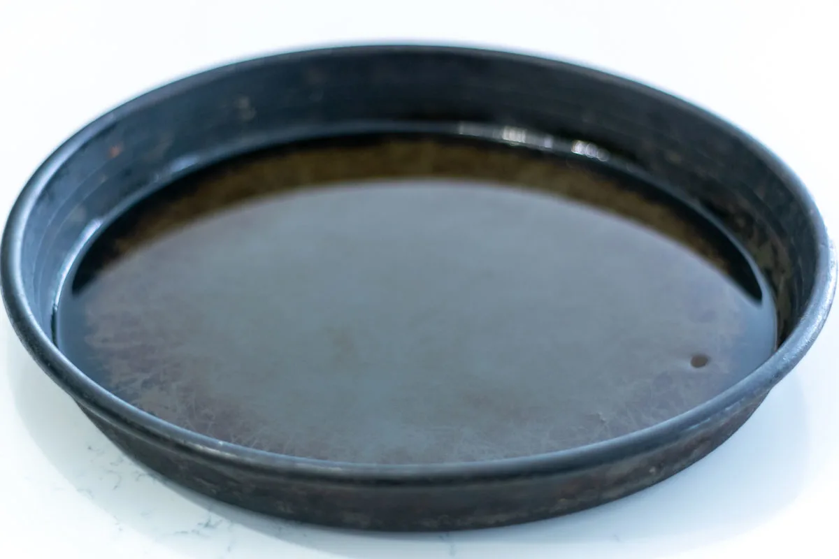 a 12 inch pizza pan with oil coating the inside.