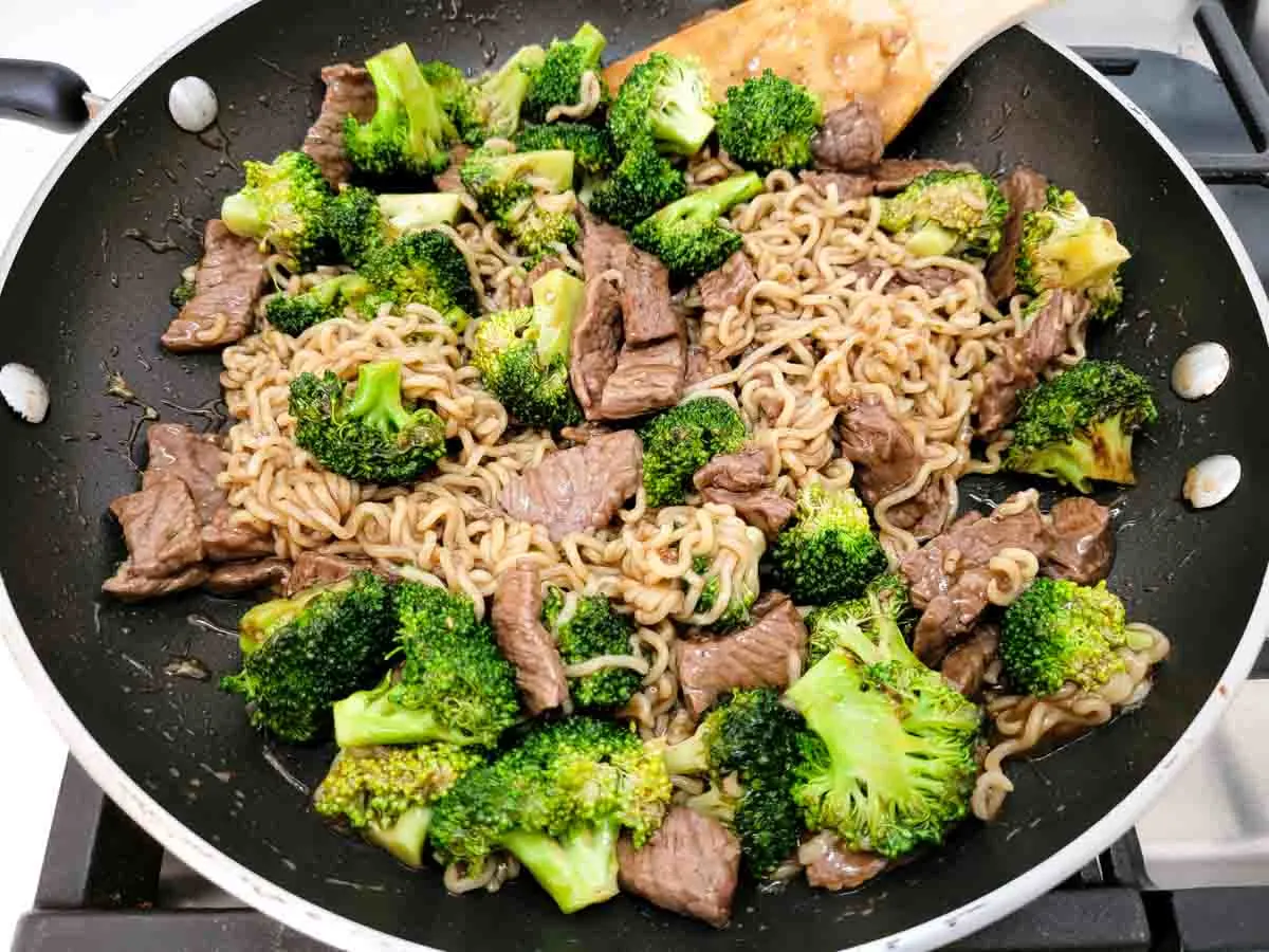 broccoli and chinese noodles mixed with sliced sirloin in a brown sauce.