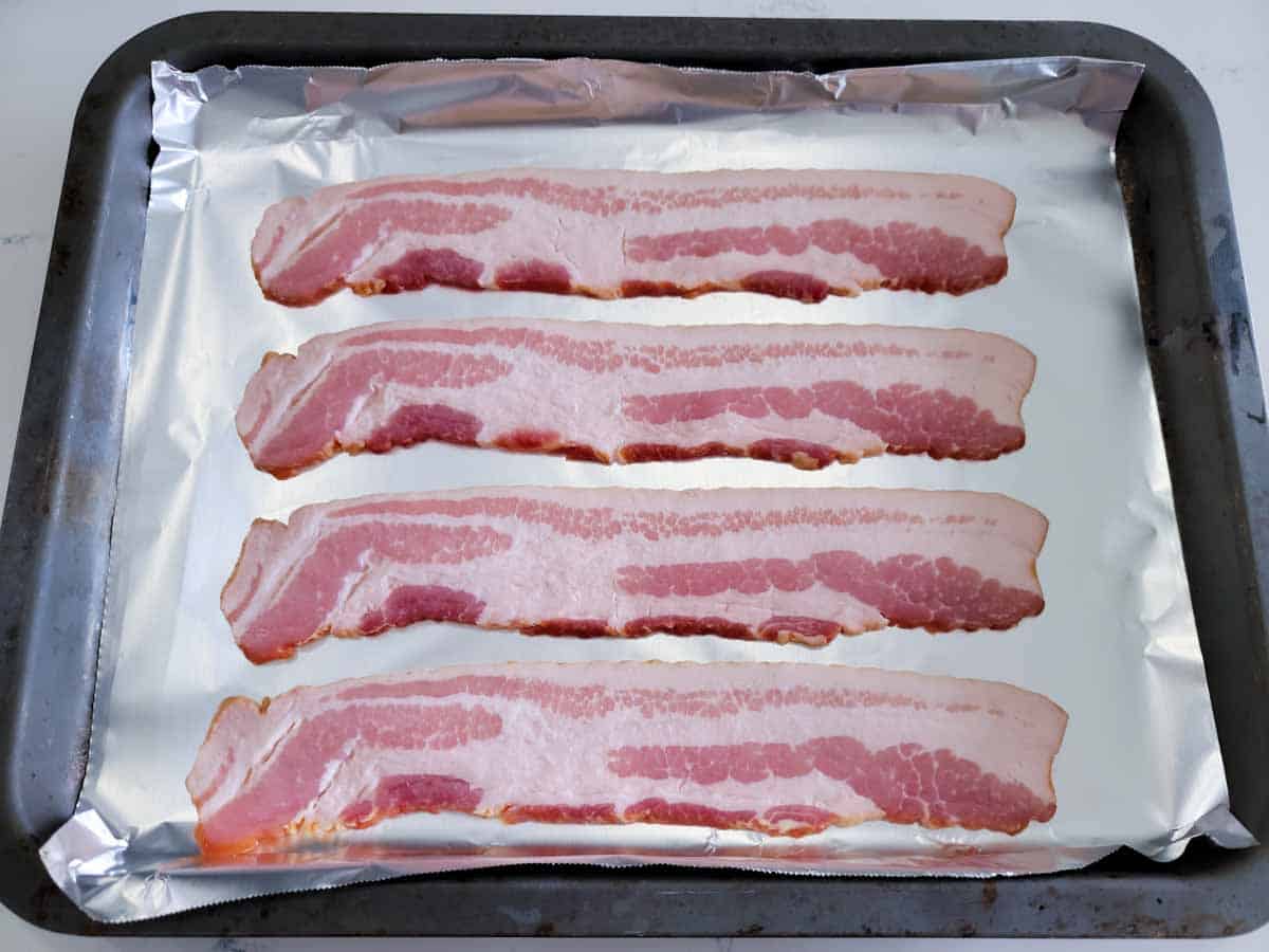 4 slices of bacon on a baking sheet.