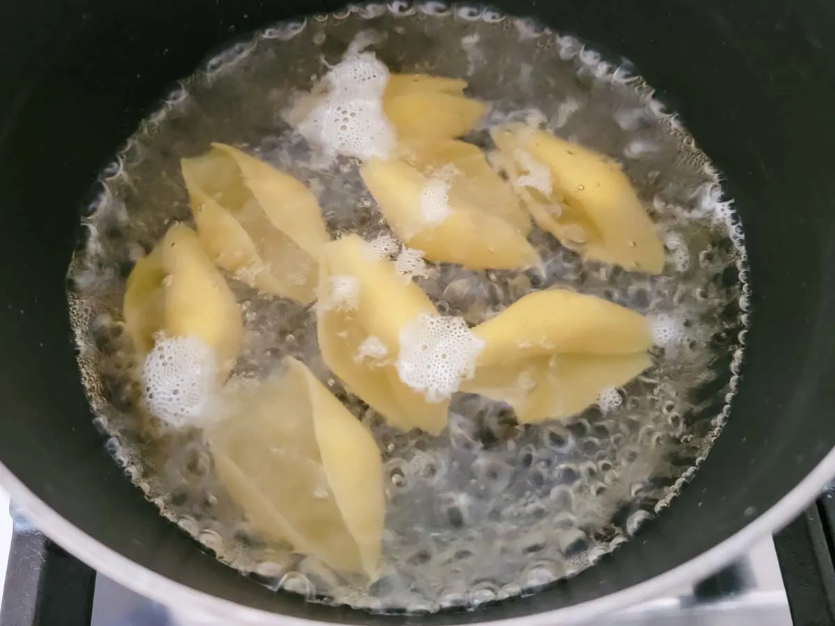 jumbo shell pasta boiling in a pan.