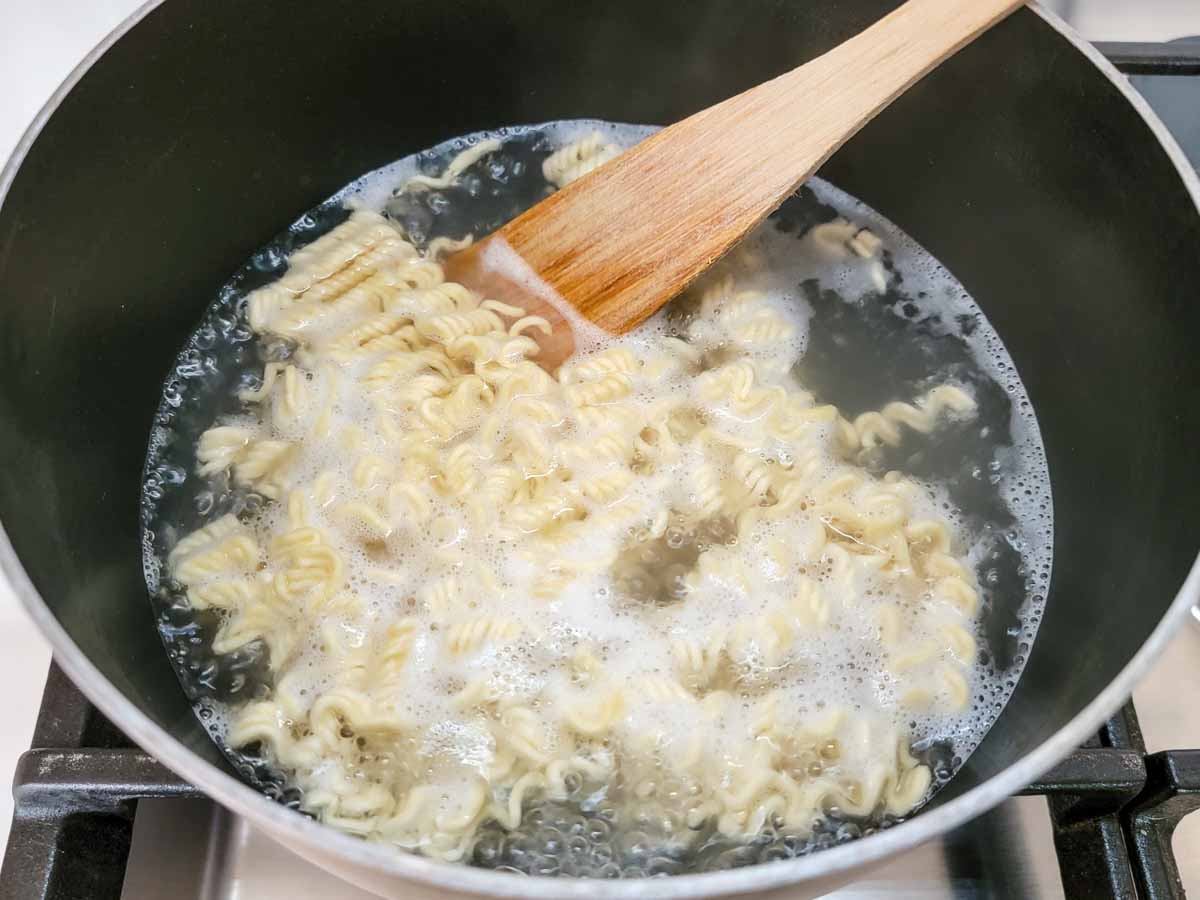 ramen noodles boiling in a pan.