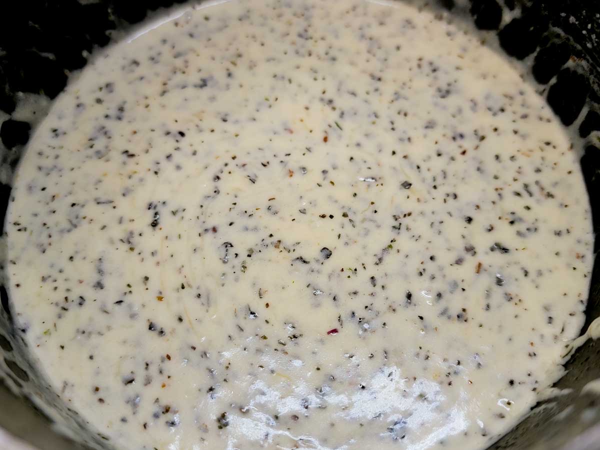 cream basil sauce cooking in a pan.