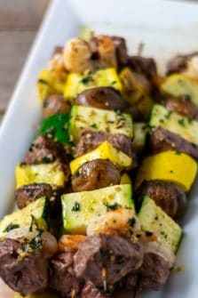 Grilled Steak and Shrimp Kabobs on a plate.