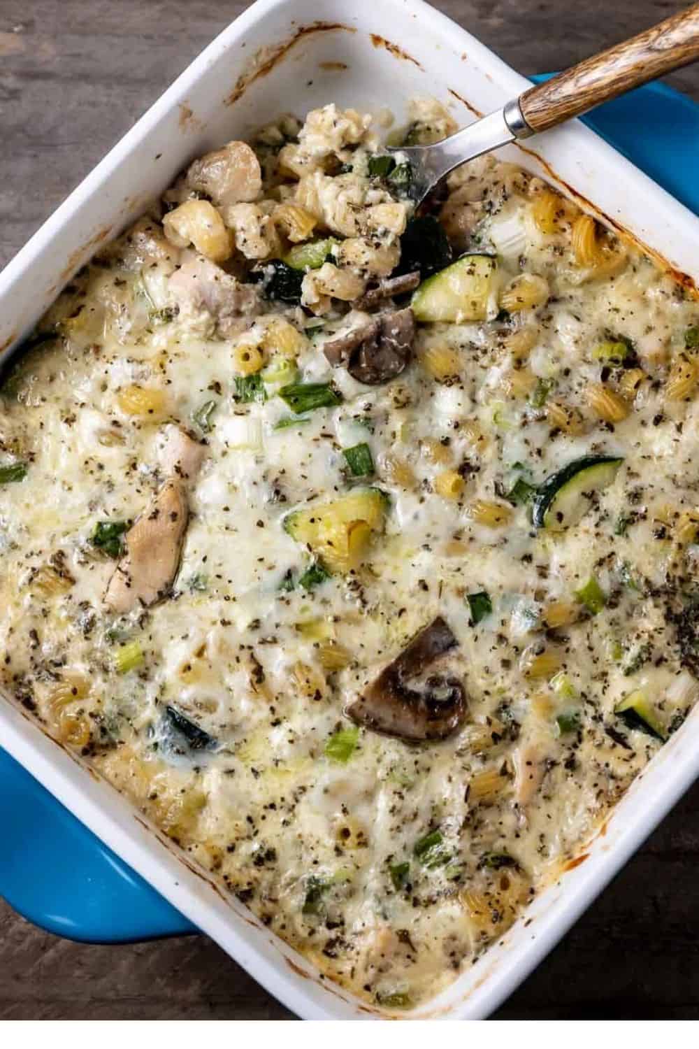 Pasta with Chicken Mushrooms and Zucchini in a casserole dish with a spoon.