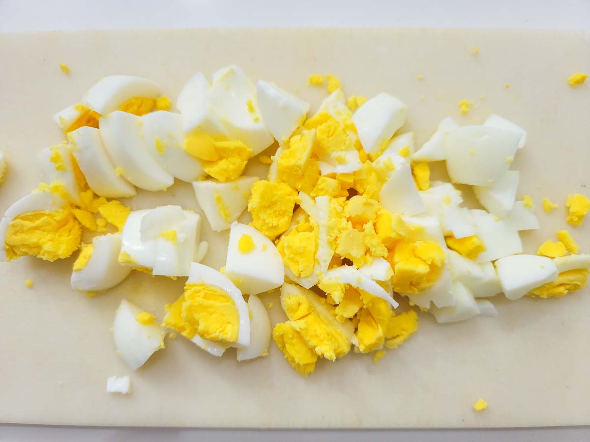 hard boiled egg chopped on a cutting board.