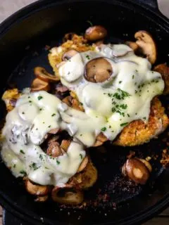 Mushroom Swiss Chicken in a cast iron skillet.