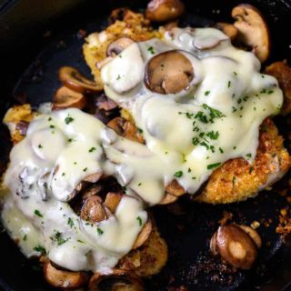 Mushroom Swiss Chicken in a cast iron skillet.