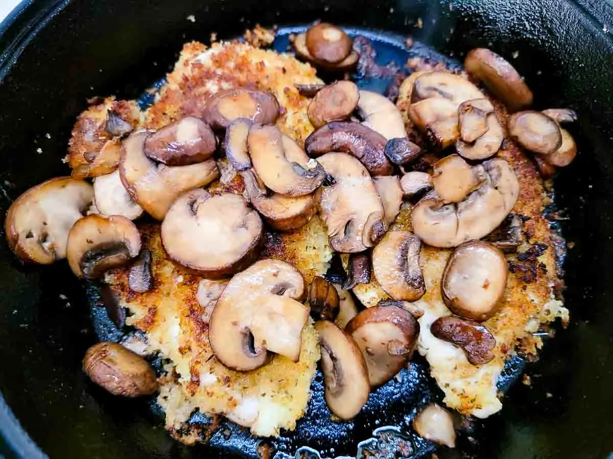 chicken and mushrooms in a skillet.