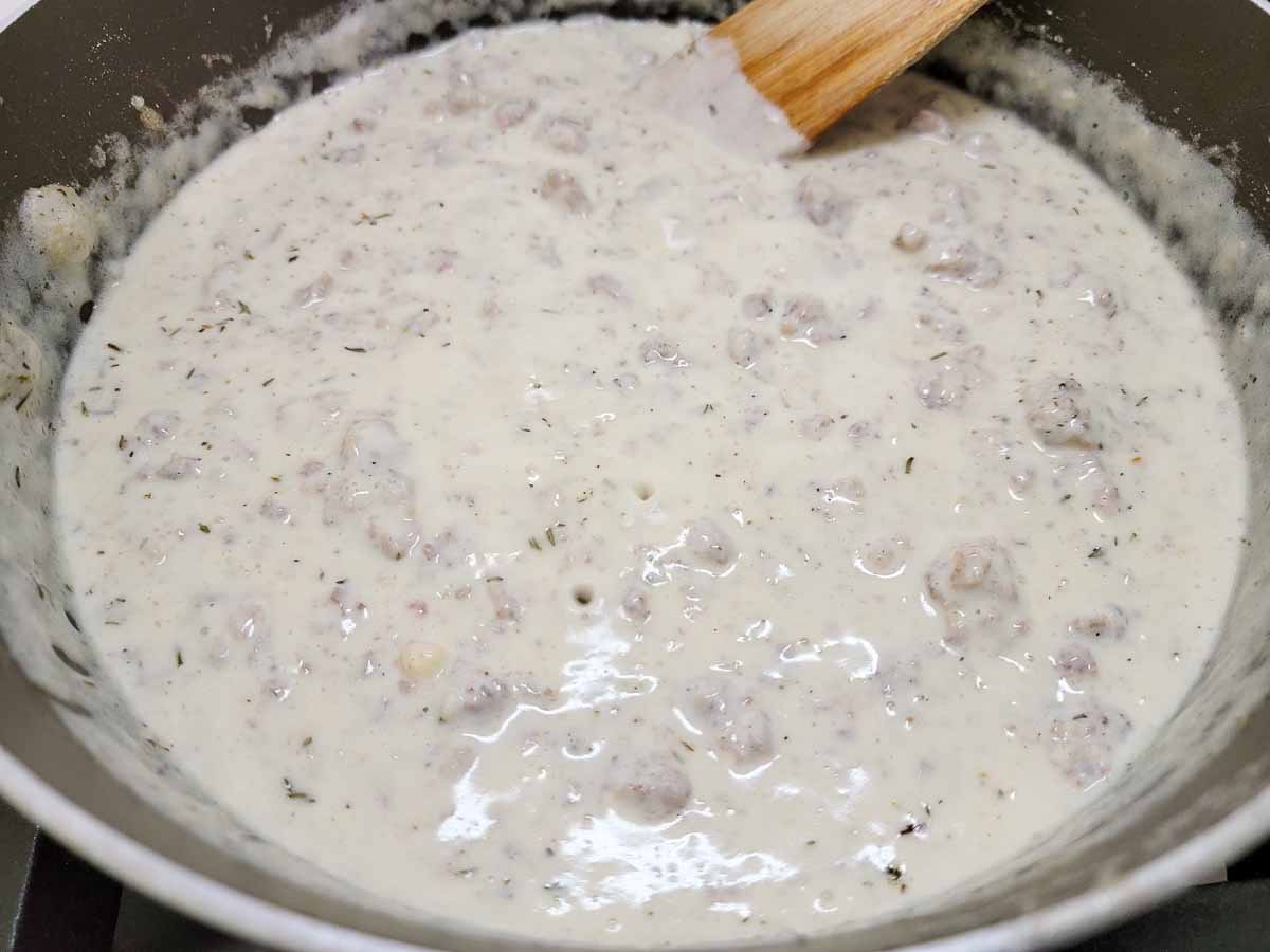 skillet sausage gravy cooking in a pan.