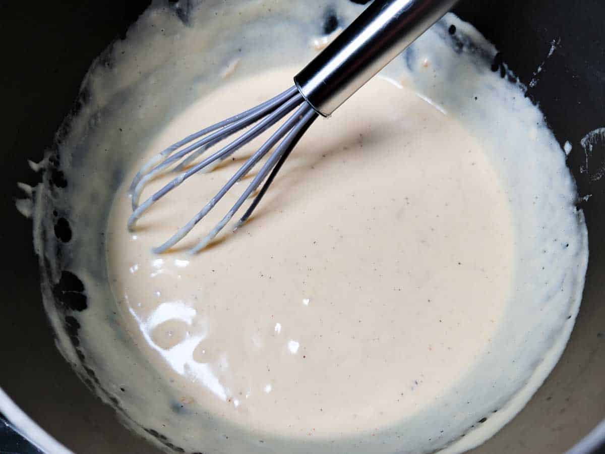 seasonings stirred into heavy cream mixture in a pan.