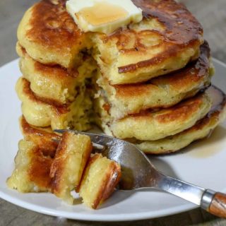 Banana Flapjacks in a stack on a plate and a fork taking one bite.