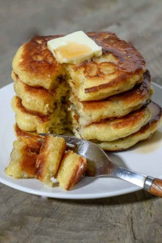 Banana Flapjacks in a stack on a plate and a fork taking one bite.