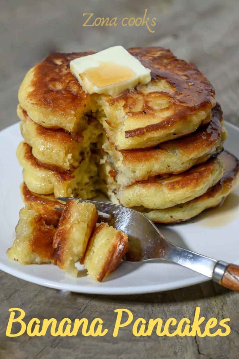 Buttermilk Banana Pancakes in a stack on a plate and a fork taking one bite.