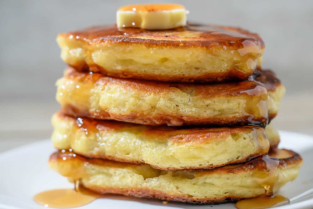 Banana Flapjacks in a stack on a plate and a fork taking one bite.