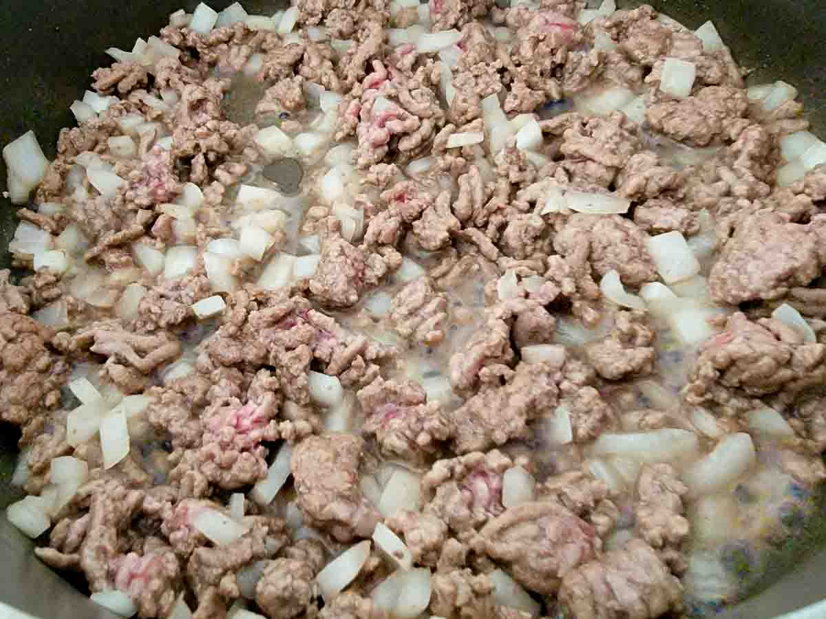 ground beef and onion cooking in a pan.