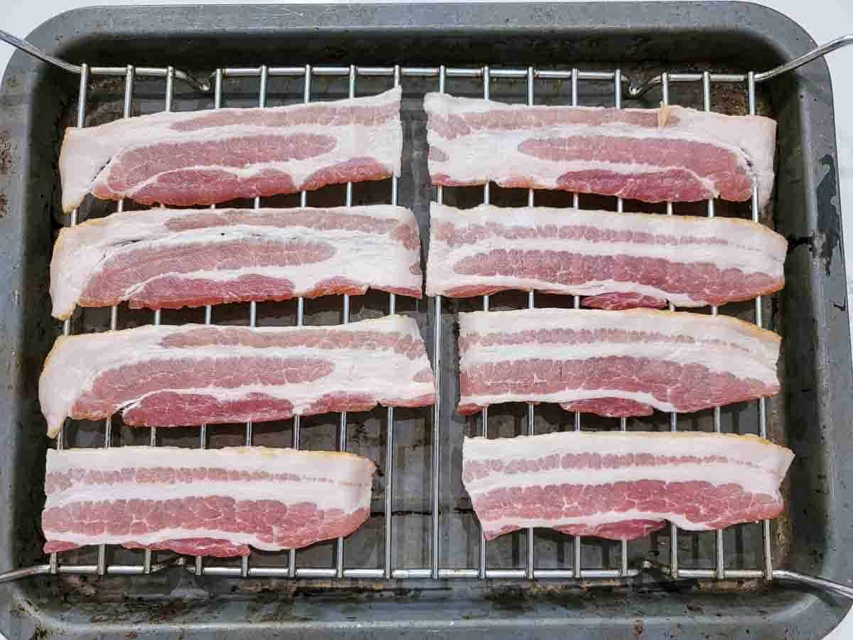 8 half bacon slices on a wire rack over a baking sheet.