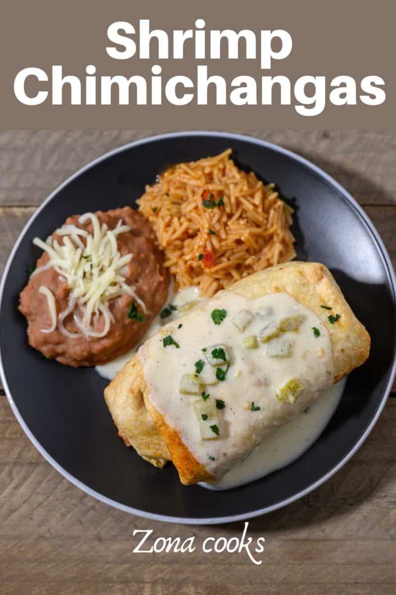 Seafood Chimichanga on a plate with sides of spanish rice and refried beans.