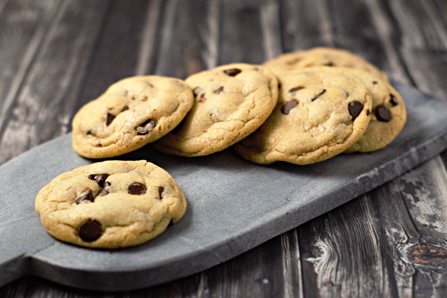 Soft Batch Chocolate Chip Cookies laying on a cutting board.