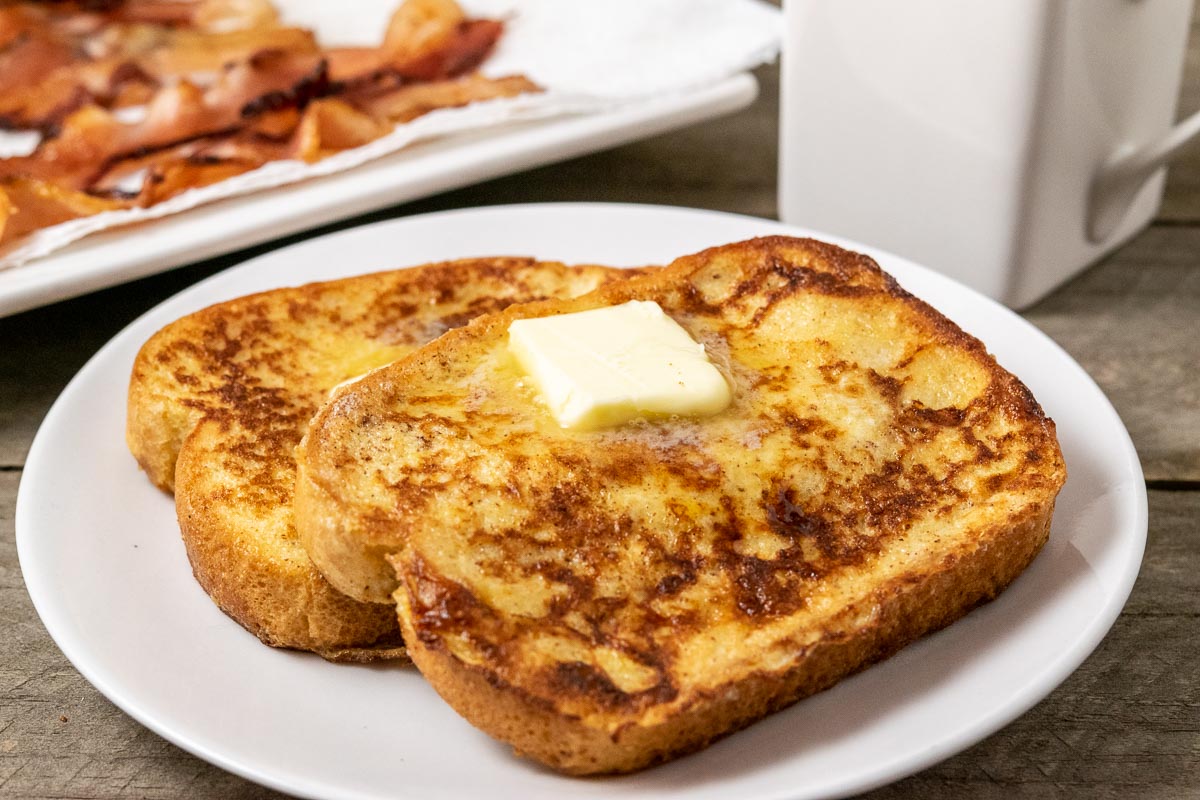 15 Minute Texas French Toast slices on a plate topped with butter and syrup.