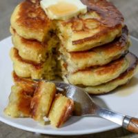 Banana Flapjacks in a stack on a plate and a fork taking one bite.