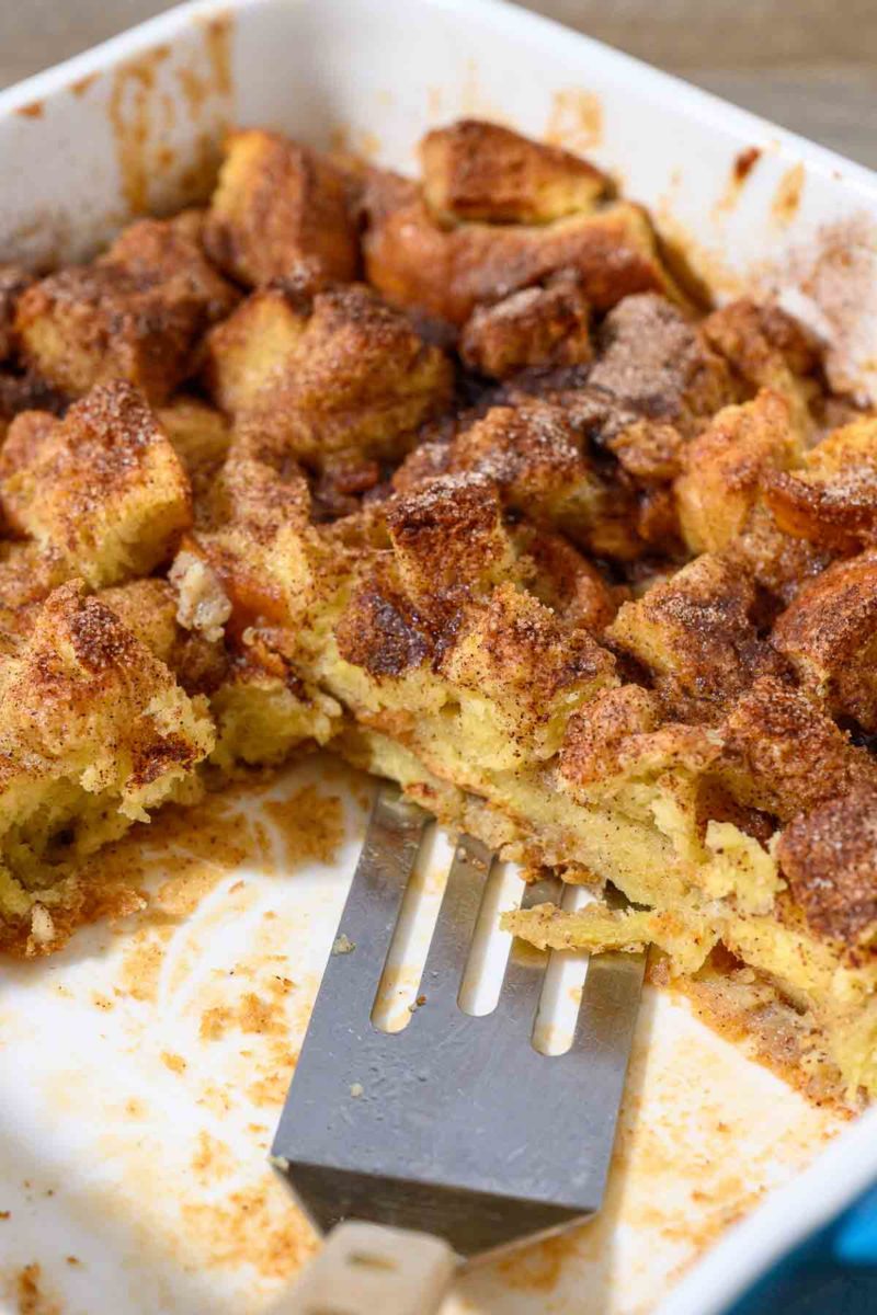 French Toast Casserole Brioche with a spatula in a baking dish.