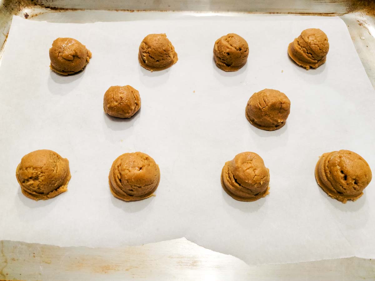 cookie dough balls on a baking sheet.