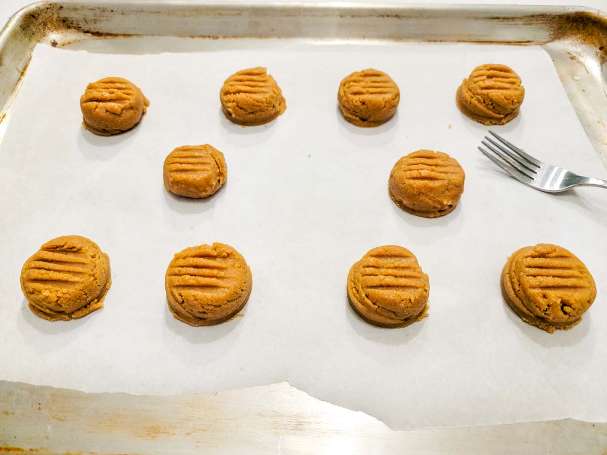 cookie dough balls pressed with fork marks on top.