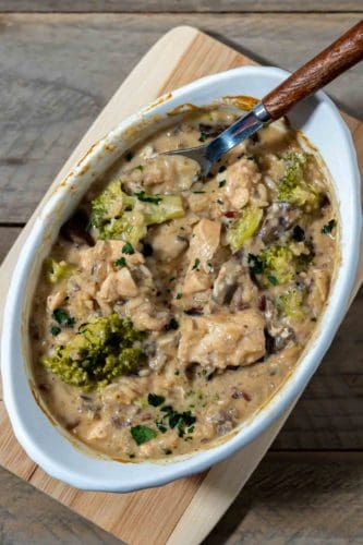 Smothered Chicken and Rice in a baking dish with a spoon.