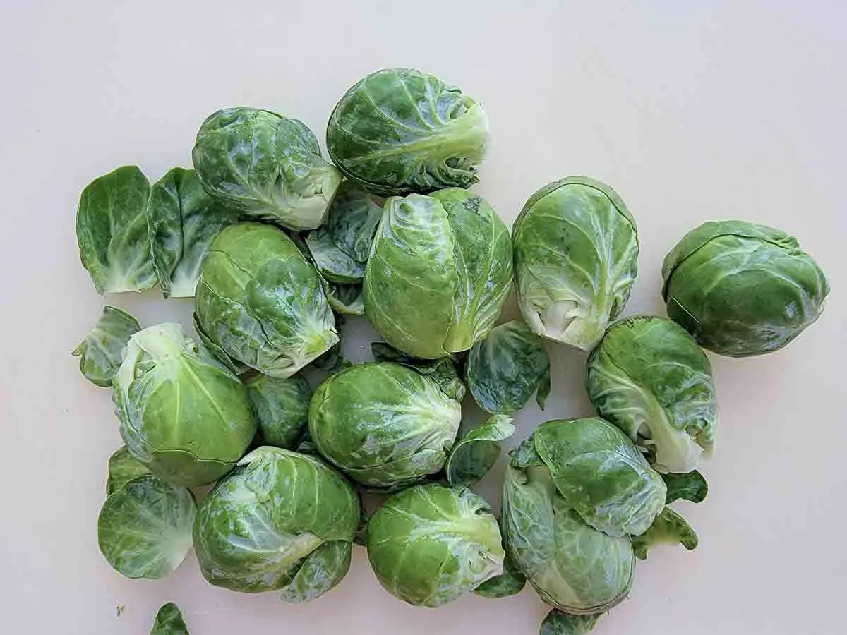 fresh brussel sprouts on a cutting board.