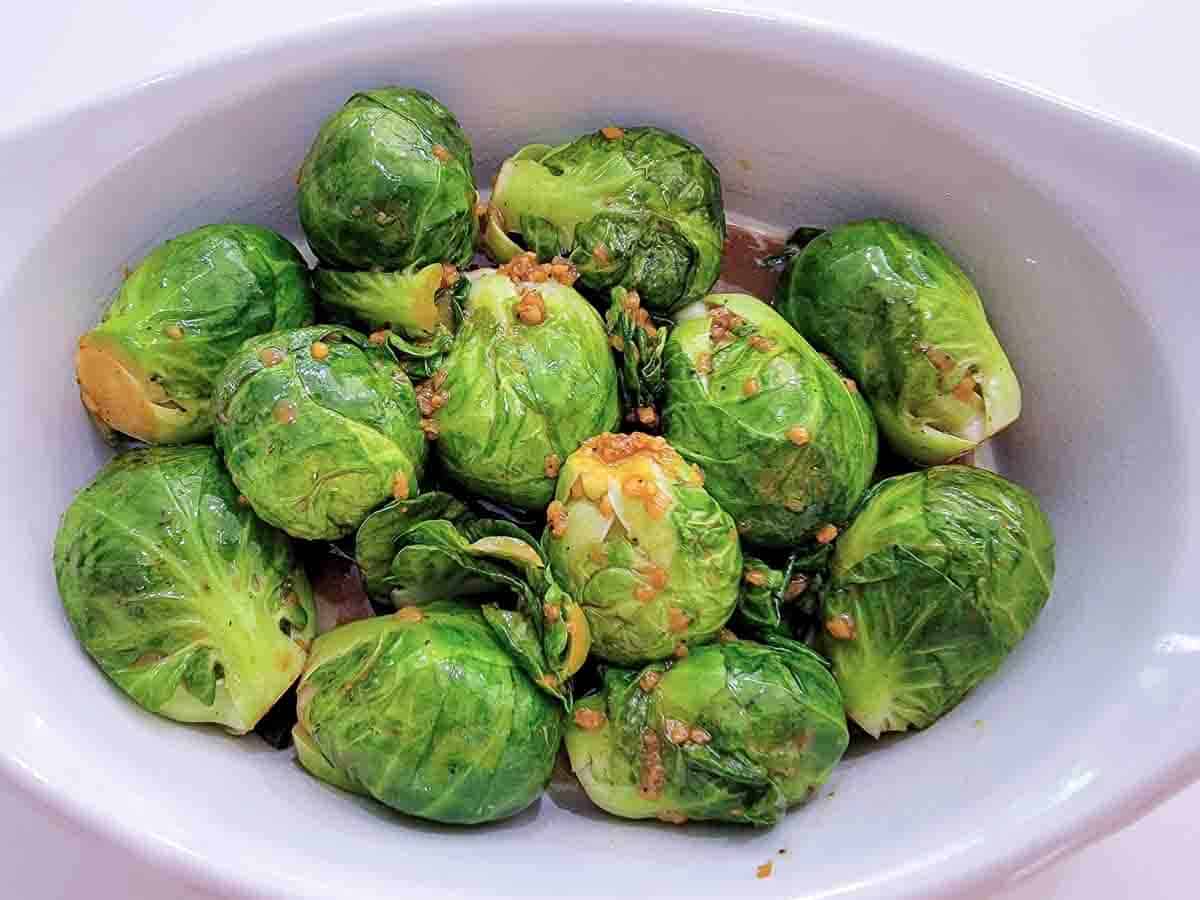 brussel sprouts and sauce in a baking dish.