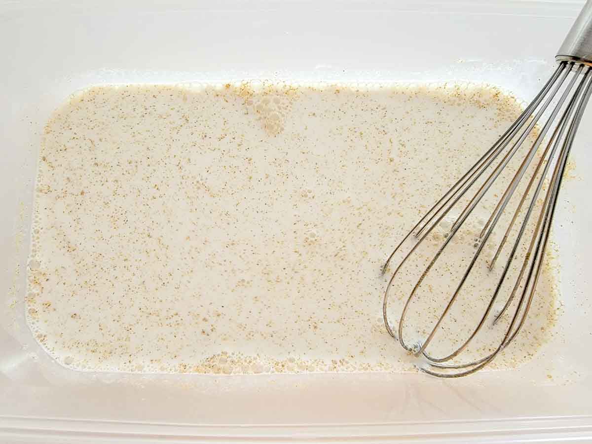 milk, vinegar, salt, and cumin whisked in a bowl.