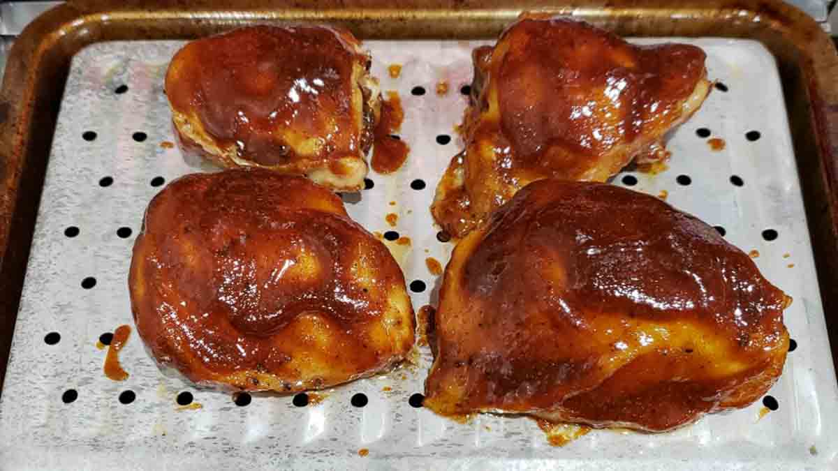 4 bbq chicken thighs on a baking sheet.
