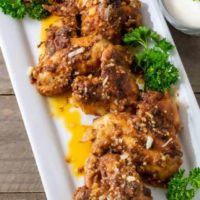 garlic parm chicken wings on a platter with a side of ranch dressing.