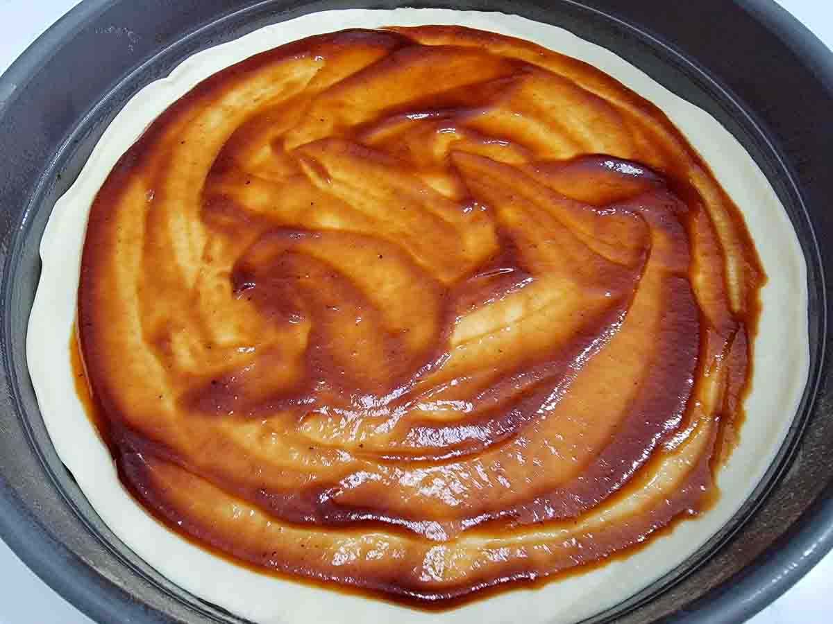 pizza dough covered in pizza sauce.