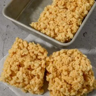 Small Batch Rice Krispie Treats with two on parchment paper and two in the pan.