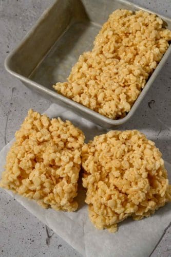 Small Batch Rice Krispie Treats with two on parchment paper and two in the pan.