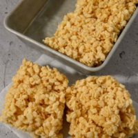 Small Batch Rice Krispie Treats with two on parchment paper and two in the pan.