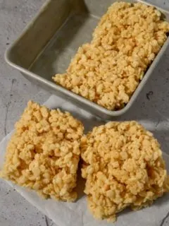 Small Batch Rice Krispie Treats with two on parchment paper and two in the pan.