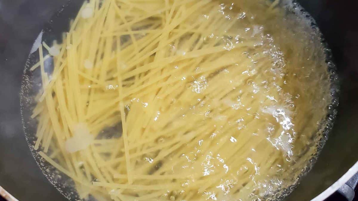 spaghetti pasta cooking in a pan.