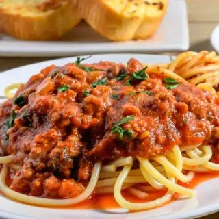 Spaghetti Sauce with Ground Beef over pasta on a plate.