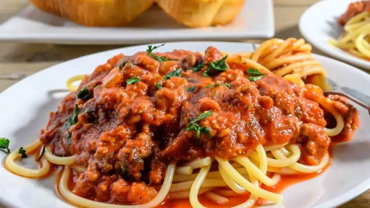 Spaghetti Sauce with Ground Beef over pasta on a plate.