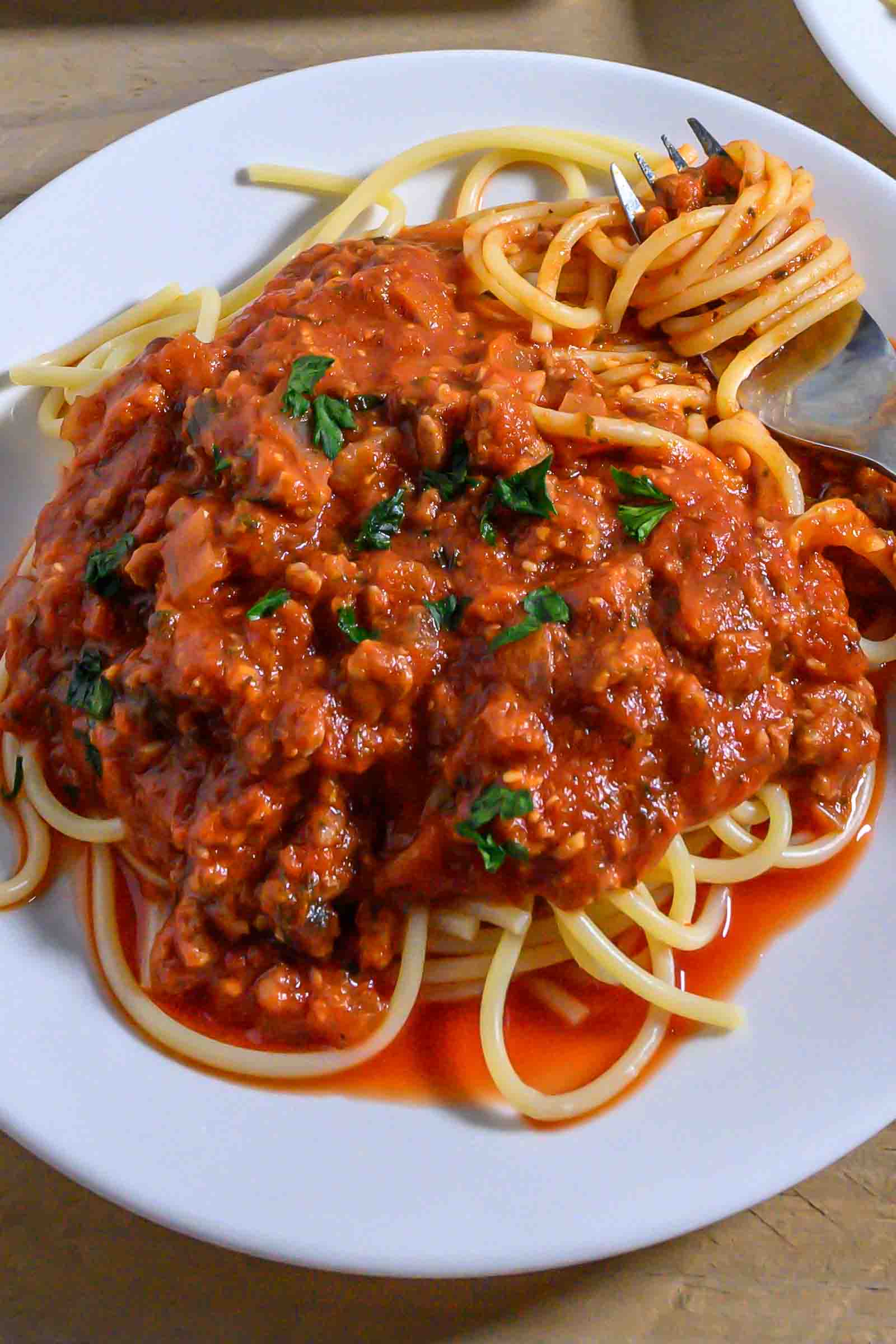 Spaghetti Sauce with Meat over pasta on a plate.