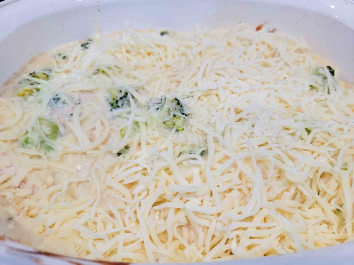 Chicken Broccoli Ravioli Alfredo topped with mozzarella cheese in a large baking dish.
