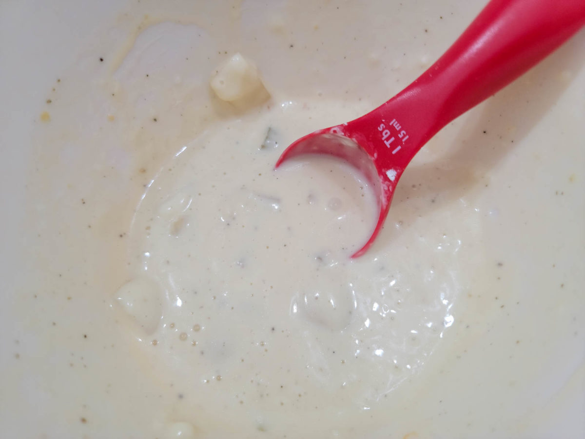 cornstarch and hot chicken broth mixed in a bowl with a tablespoon.