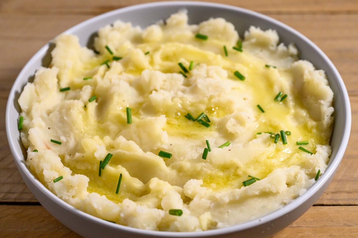 Homemade Mashed Potatoes without Milk topped with melted butter and chives.
