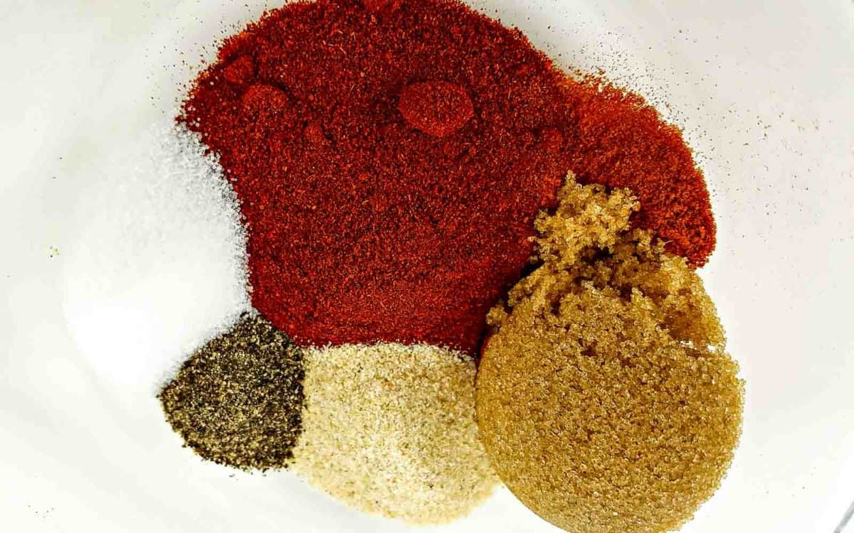paprika, brown sugar, cayenne pepper, onion powder, salt and pepper in a bowl.