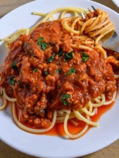 Spaghetti Sauce with Meat over pasta on a plate.