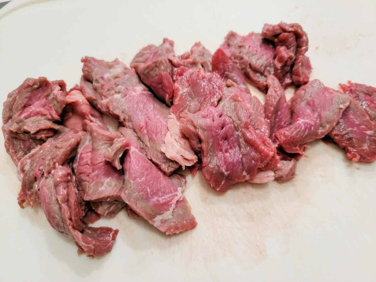 thin sliced beef on a cutting board.