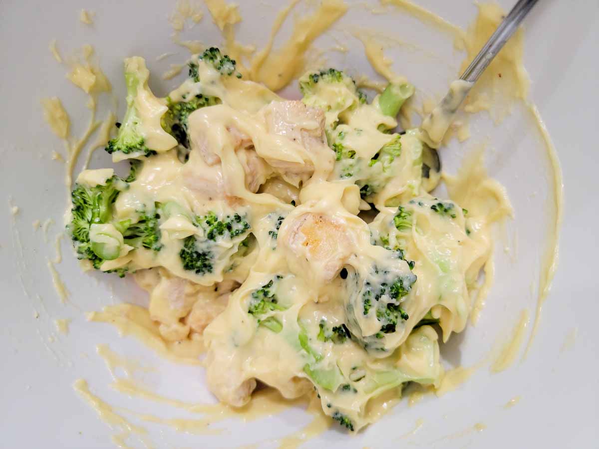 cream of chicken soup, broccoli, and chicken mixed in a pan.